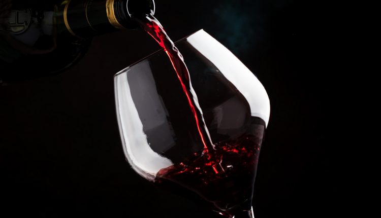 Red wine from grapes of pinot noir varieties poured into large w